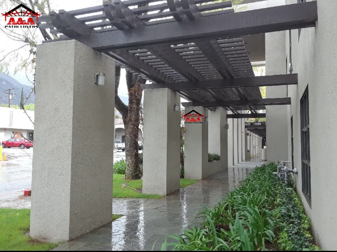 Pergola-covered walkway along a commercial building entrance