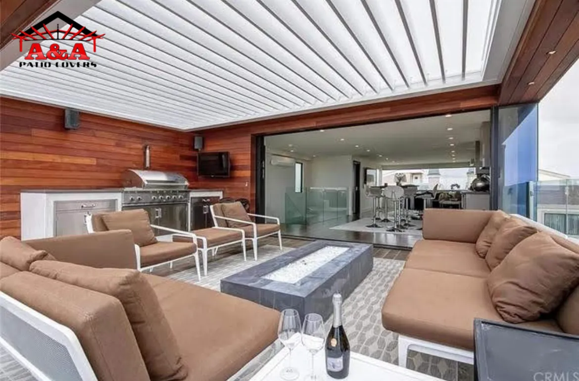 Outdoor lounge and kitchen under a solid patio cover with a warm wood-finish ceiling