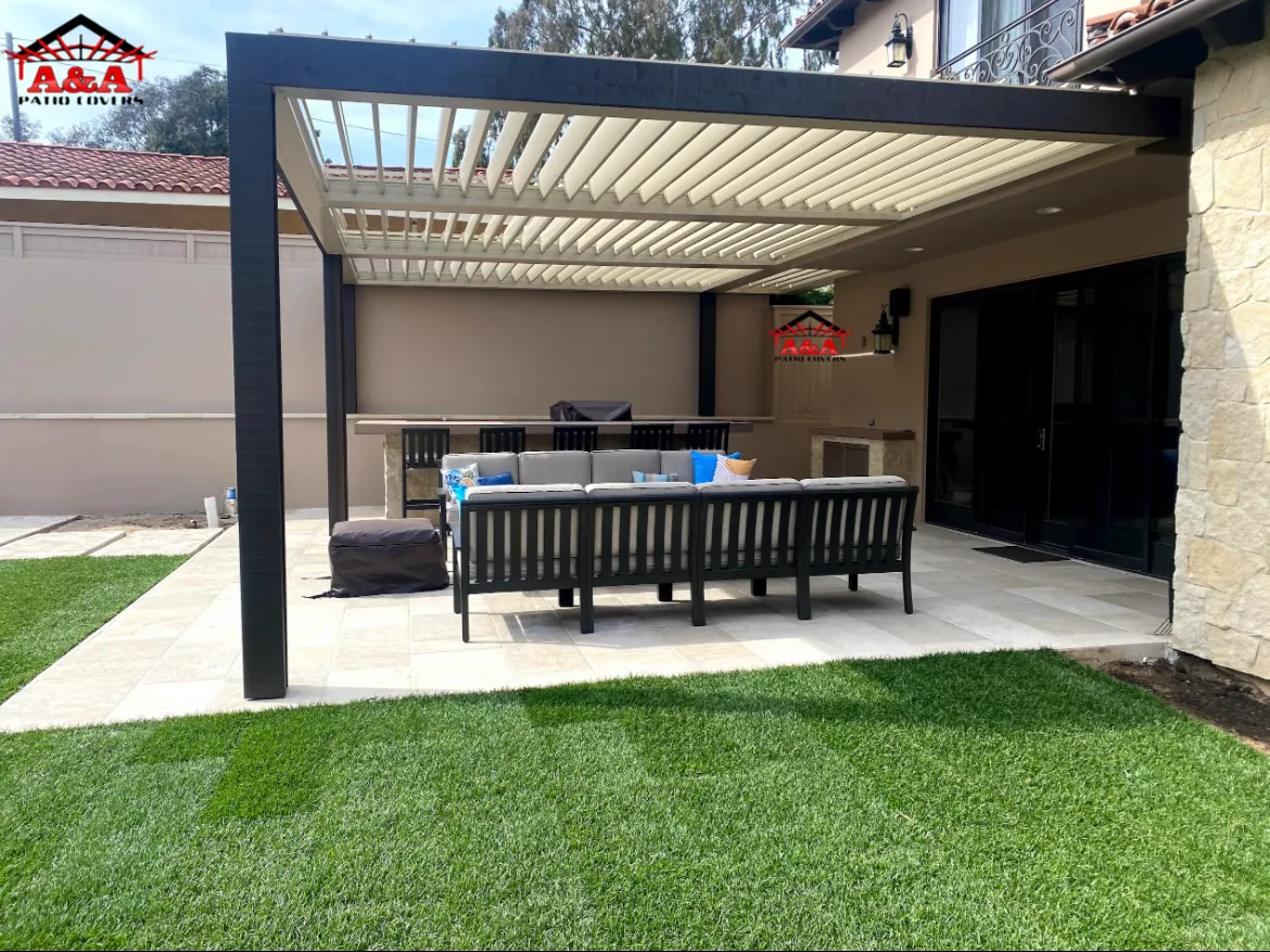 Adjustable louvered patio cover over a turf backyard and lounge seating
