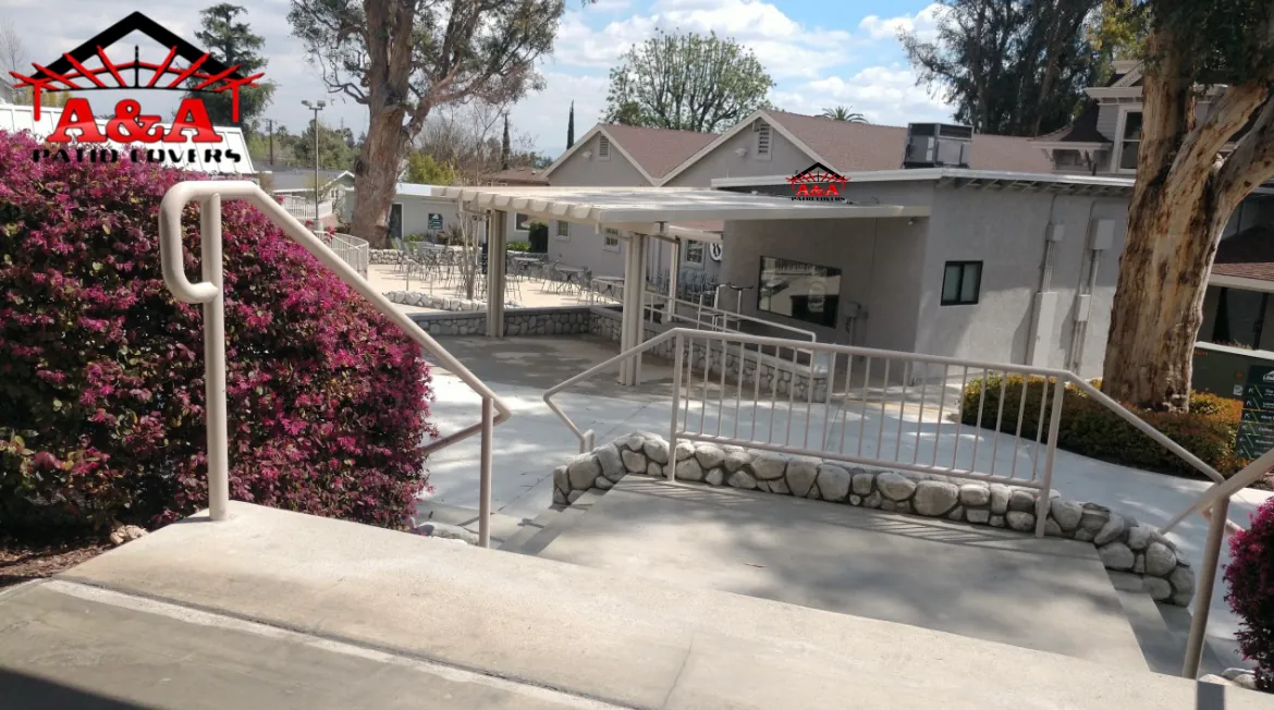 White canopy over an accessible entry ramp framed by bougainvillea